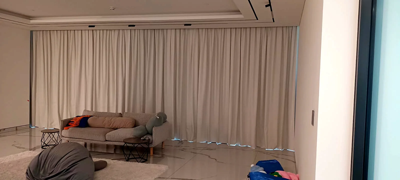Ceiling-track curtains across a large living room wall