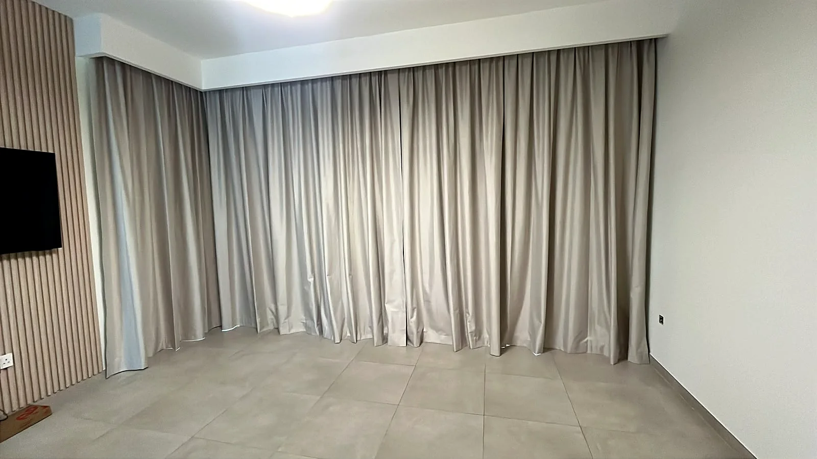 Corner ceiling-track curtains in a Dubai apartment