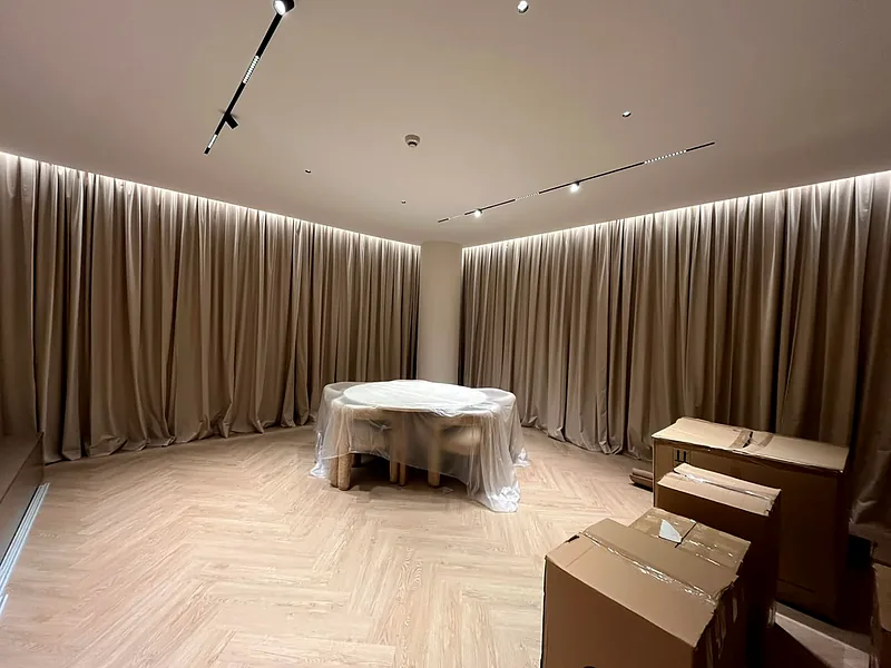 Curved-track curtains under LED cove lighting
