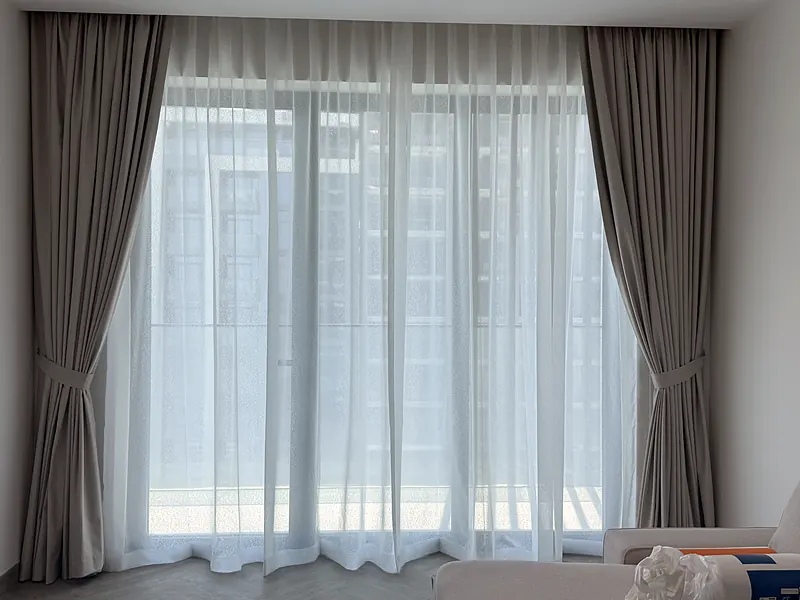 Sheer and grey curtains with tie-backs in a Dubai apartment