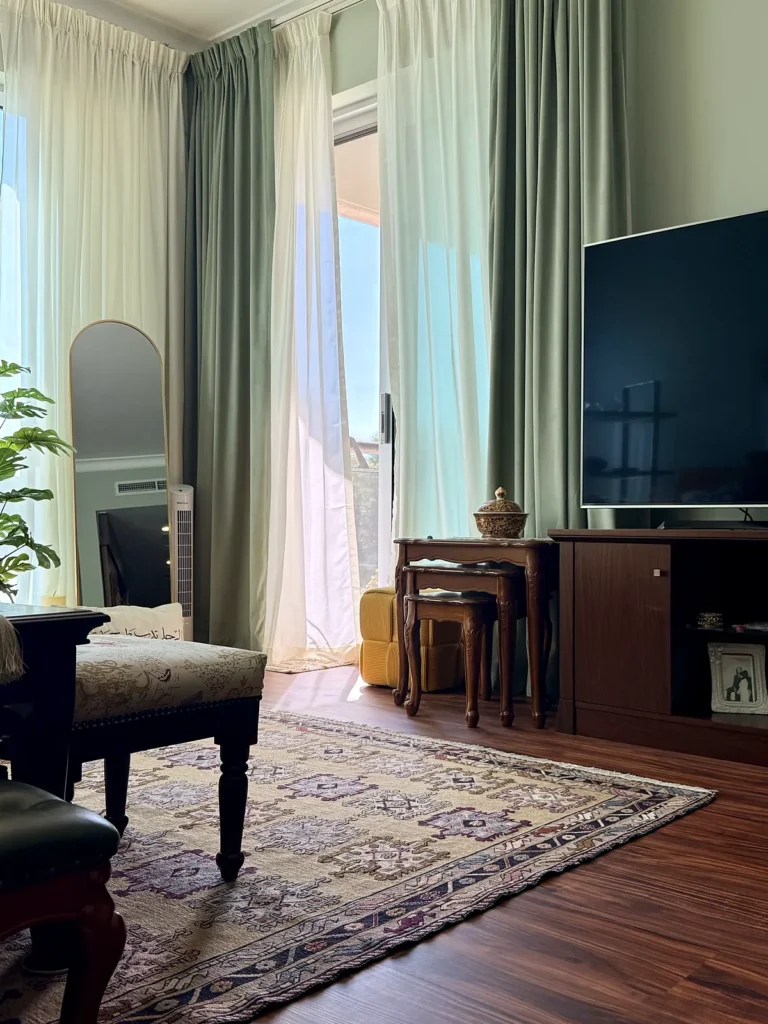 Green velvet curtains with white sheers in a Dubai living room