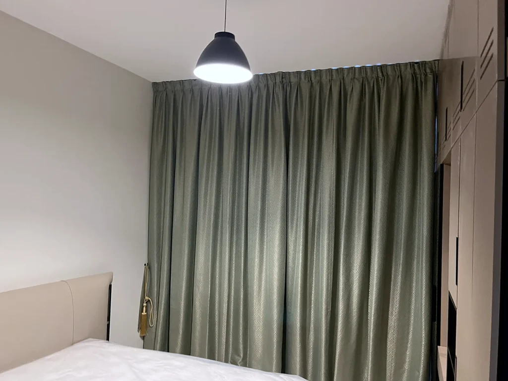 Sage green blackout curtains in a Dubai bedroom