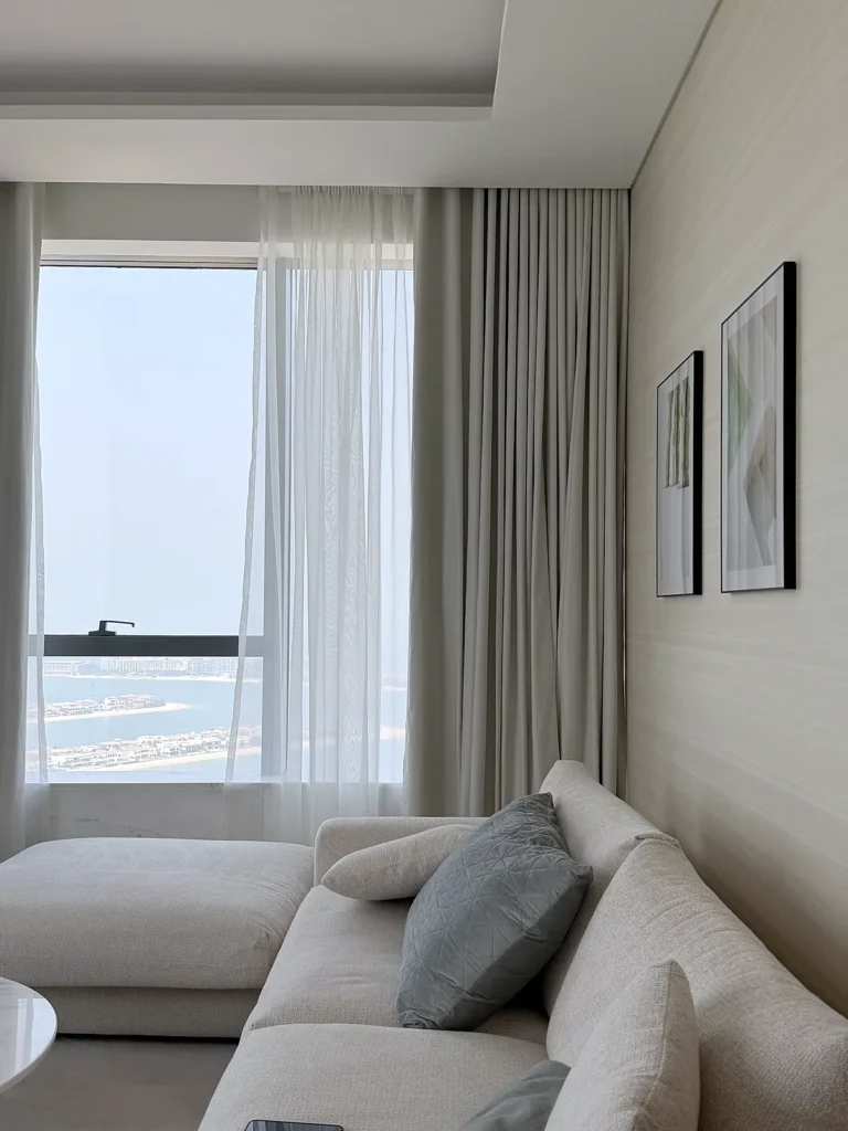Sheer and dim-out curtains with a sea view in a Dubai apartment