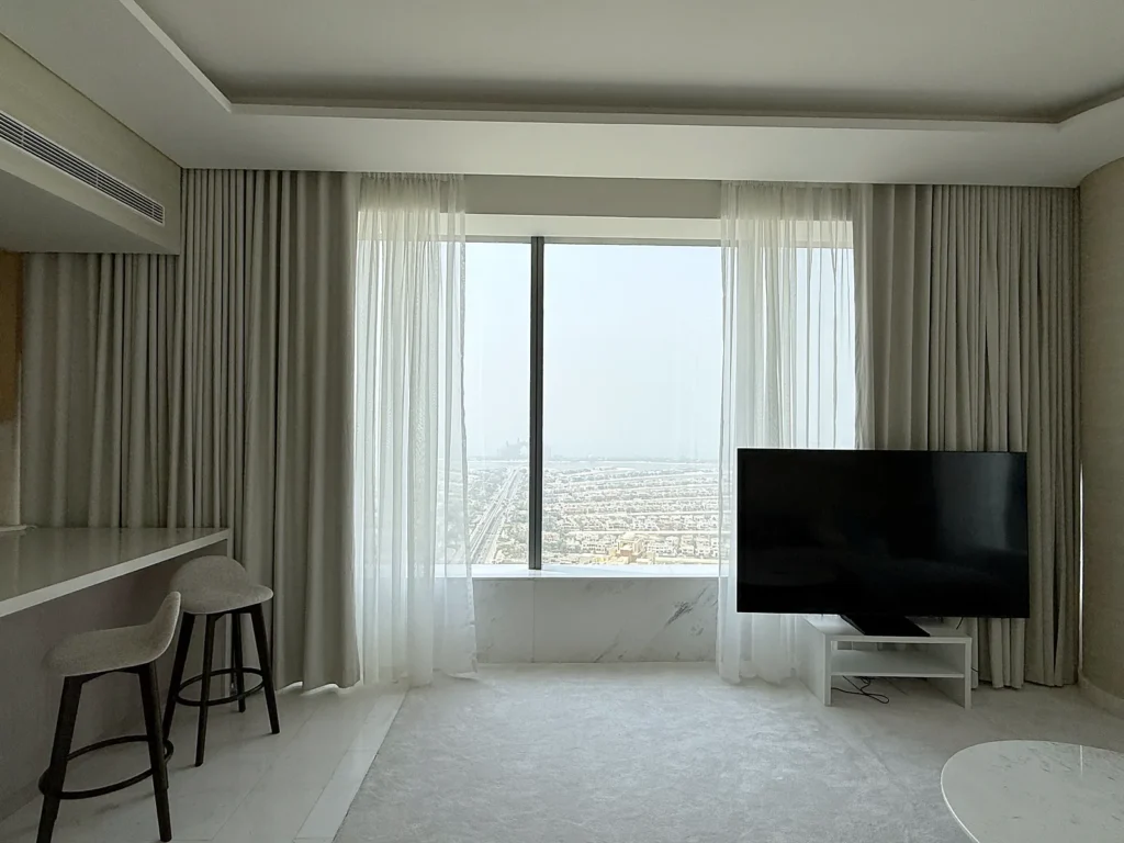 Sheer and grey curtains in a living room overlooking Palm Jumeirah