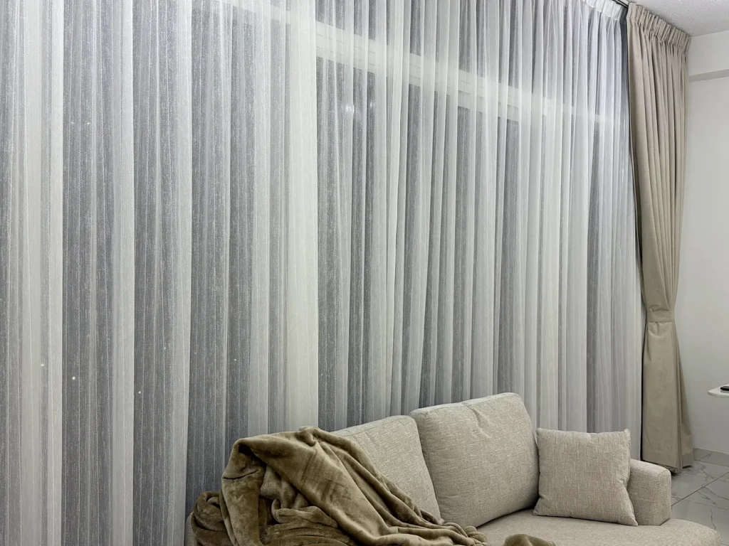 Wide sheer curtains across a living room window in Dubai